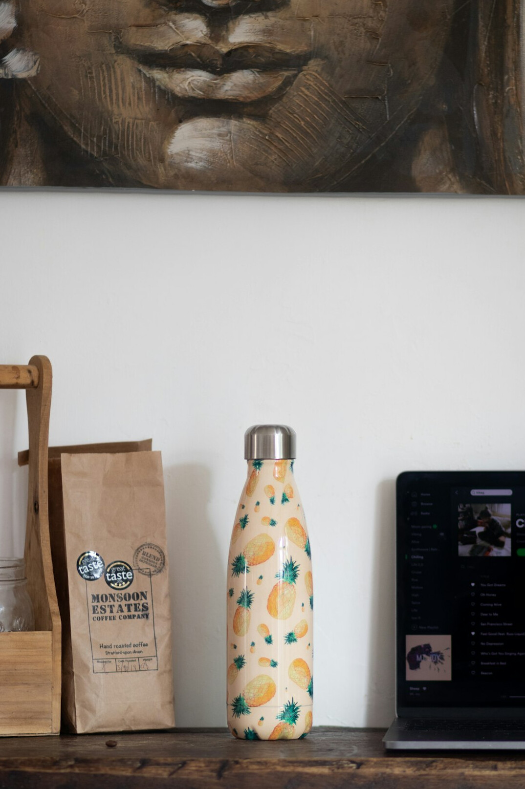 Bright home desk with notebook, laptop, plant and a mate gourd with thermos