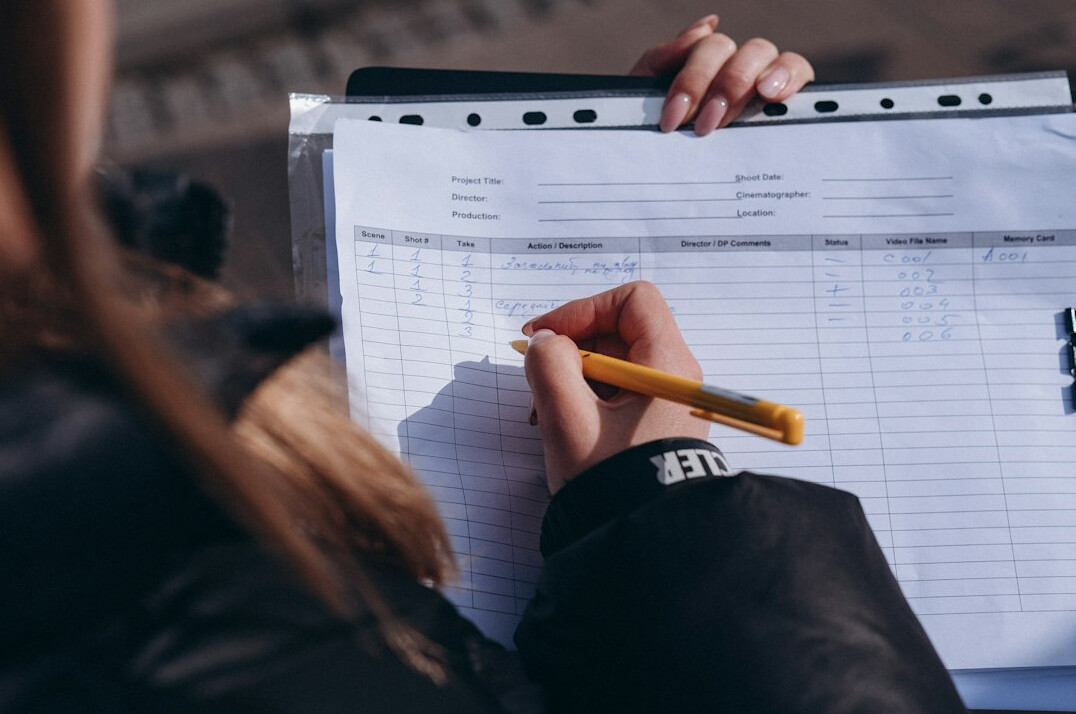 person tracking expenses in notebook
