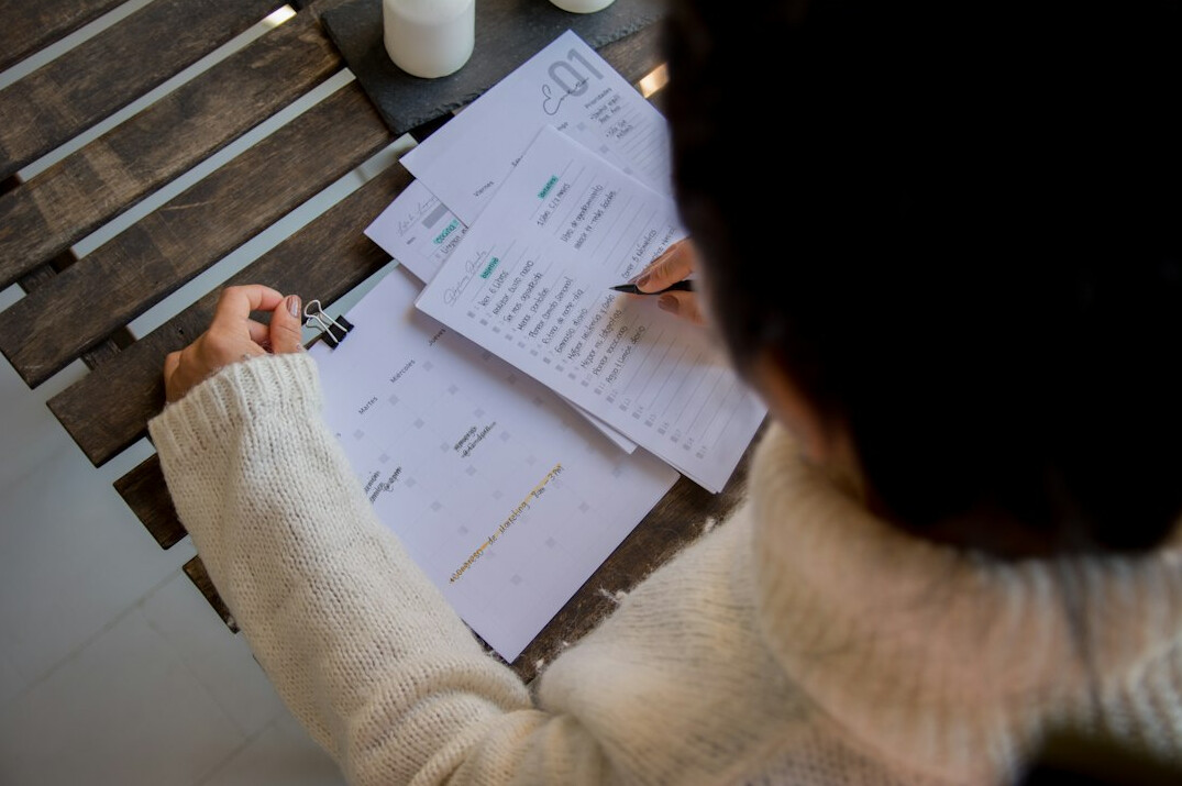 woman writing in budget planner